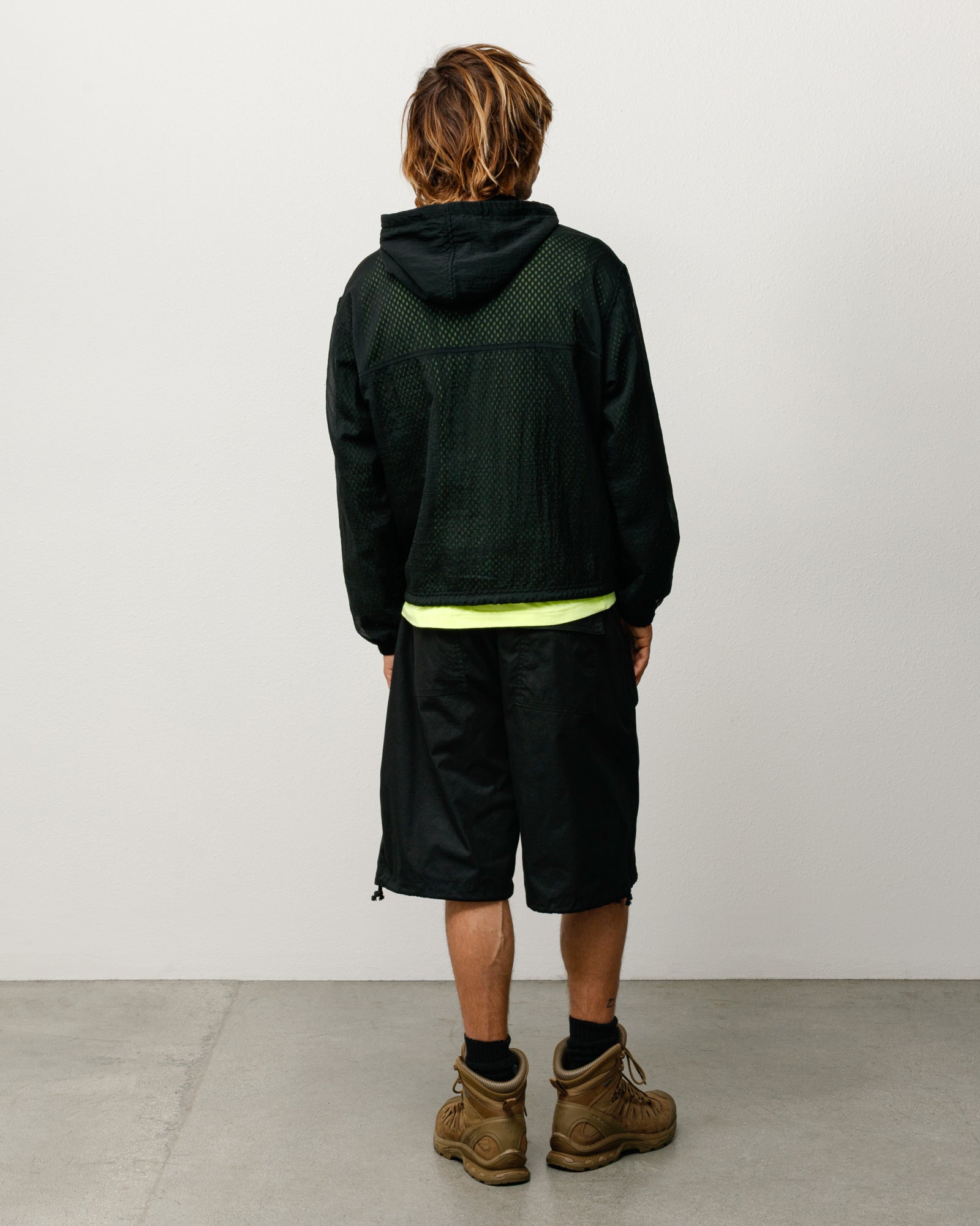 Black baggy shorts with rear patch pockets and adjustable hem cords, back view on model