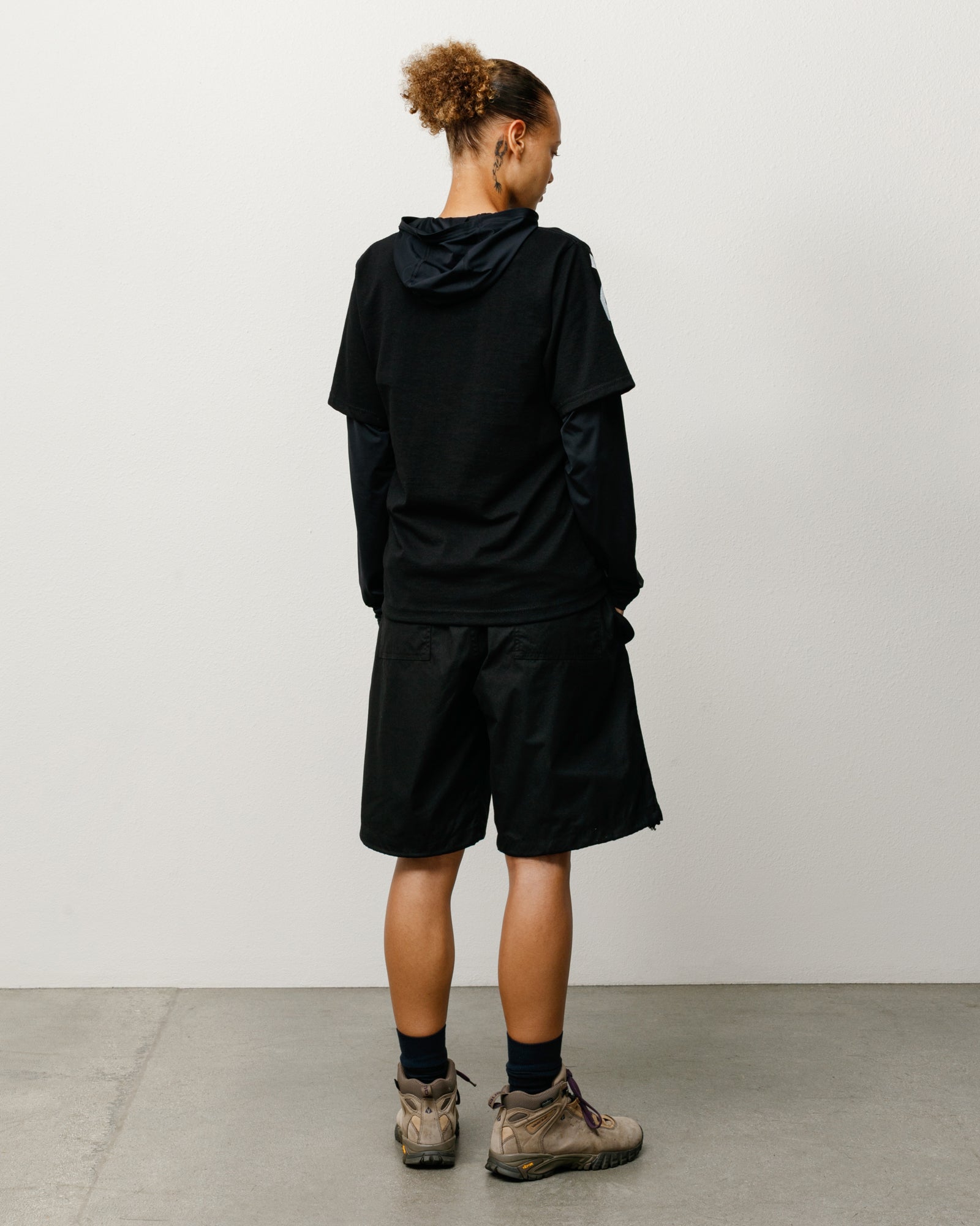 Black baggy cotton-nylon shorts on model, back view with rear patch pockets