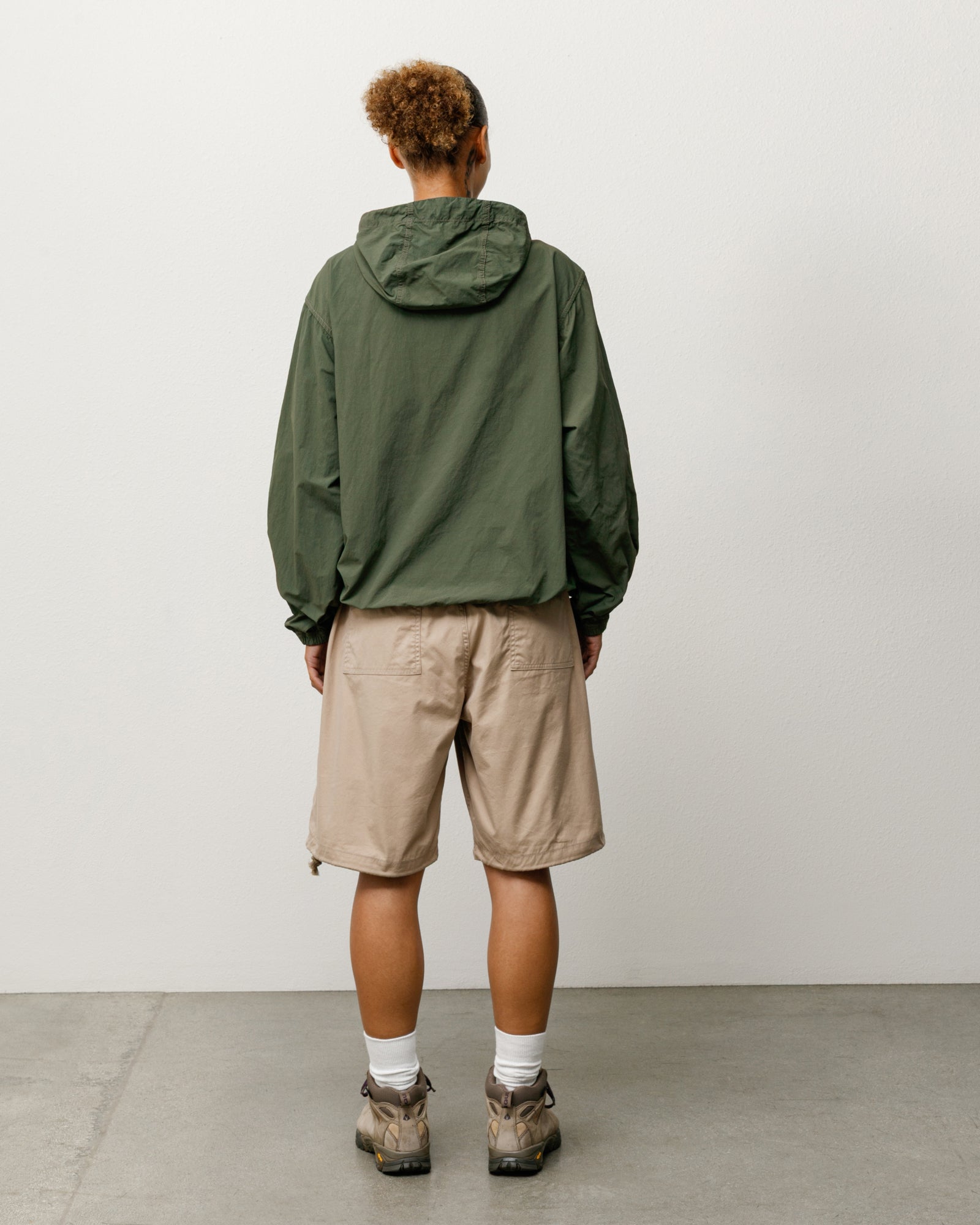 Unisex baggy khaki shorts with rear patch pockets and adjustable hem drawcords, back view