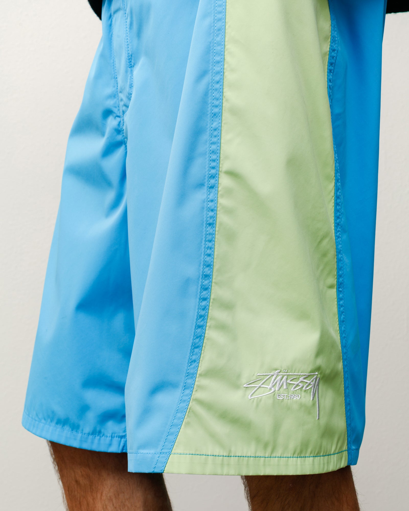 Curved Panel Board Short Bottoms in the color Light Blue with light green side panels and white Stüssy logo embroidery.