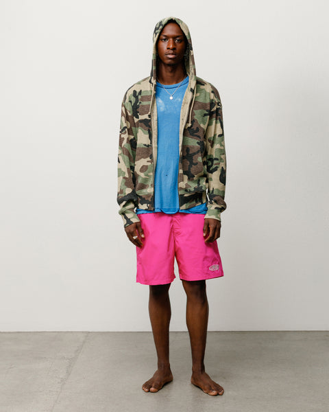 Pink unisex board short on model with drawcord waist and logo at hem