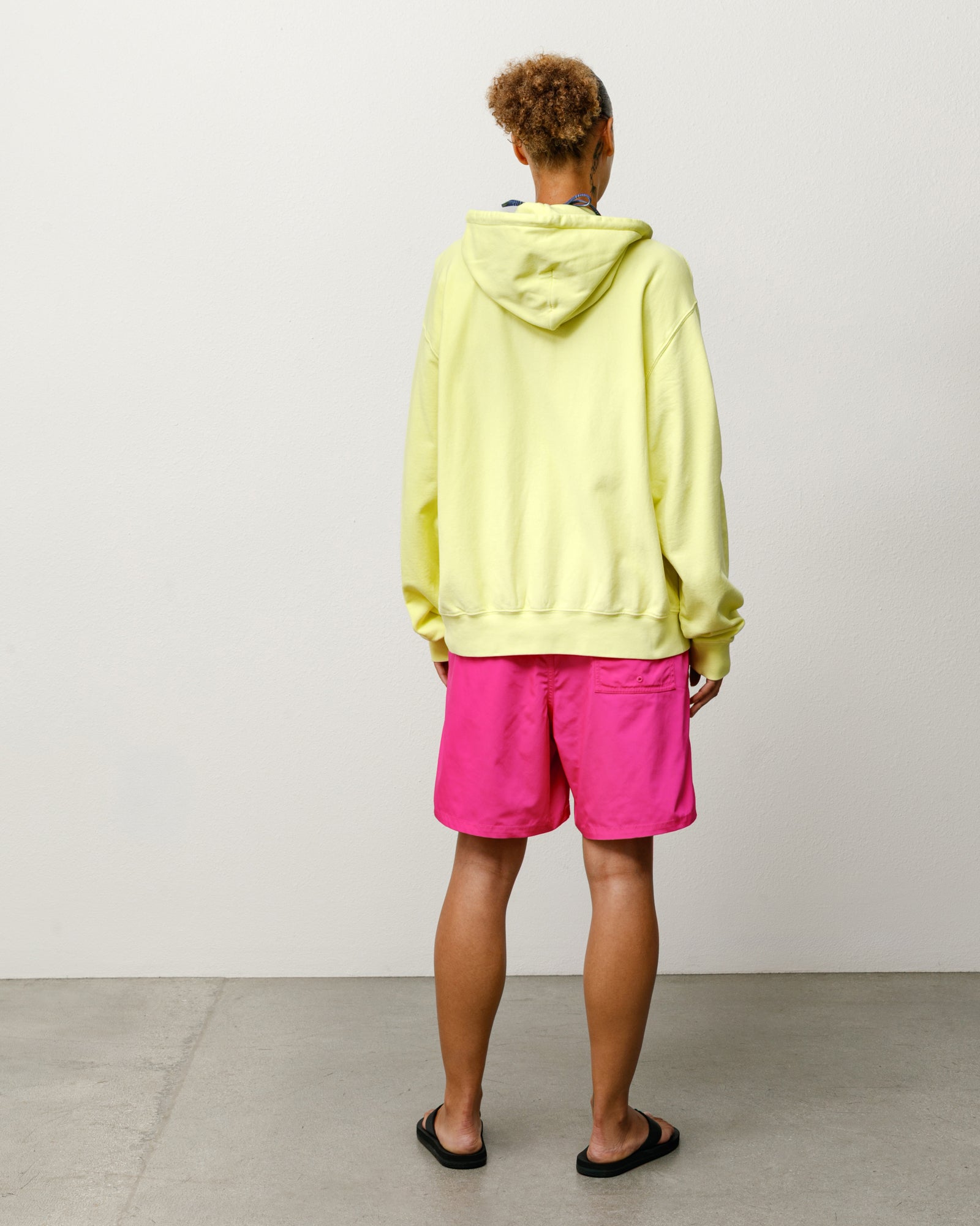 Pink coastal board short on-model, back view showing rear patch pocket