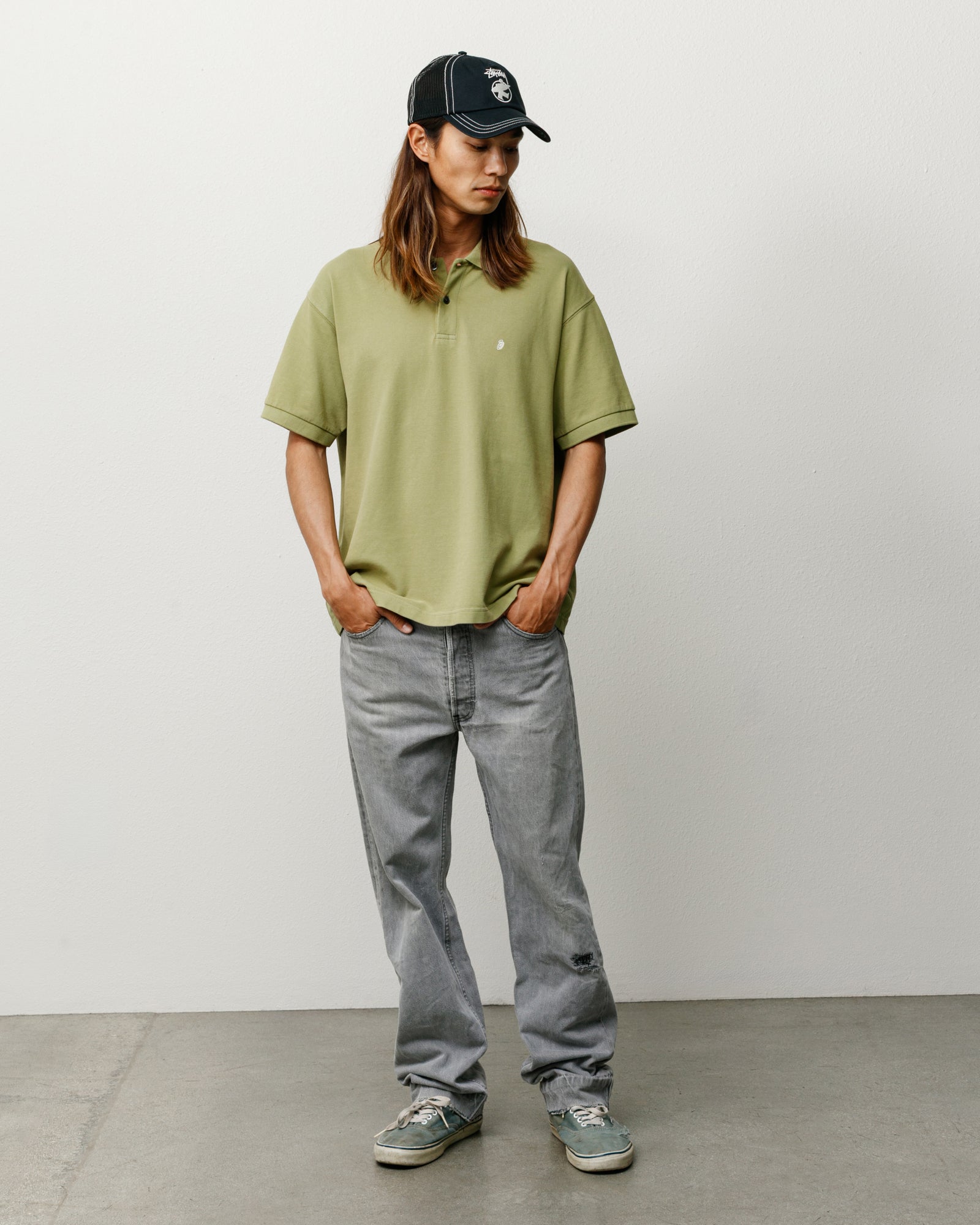 Leaf green piqué polo shirt, short-sleeved cotton with ribbed collar, model wearing