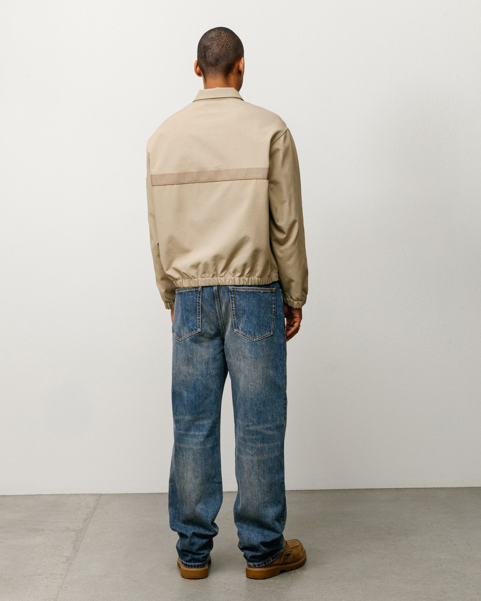Khaki mechanic jacket, back view with horizontal webbing stripe and elastic hem