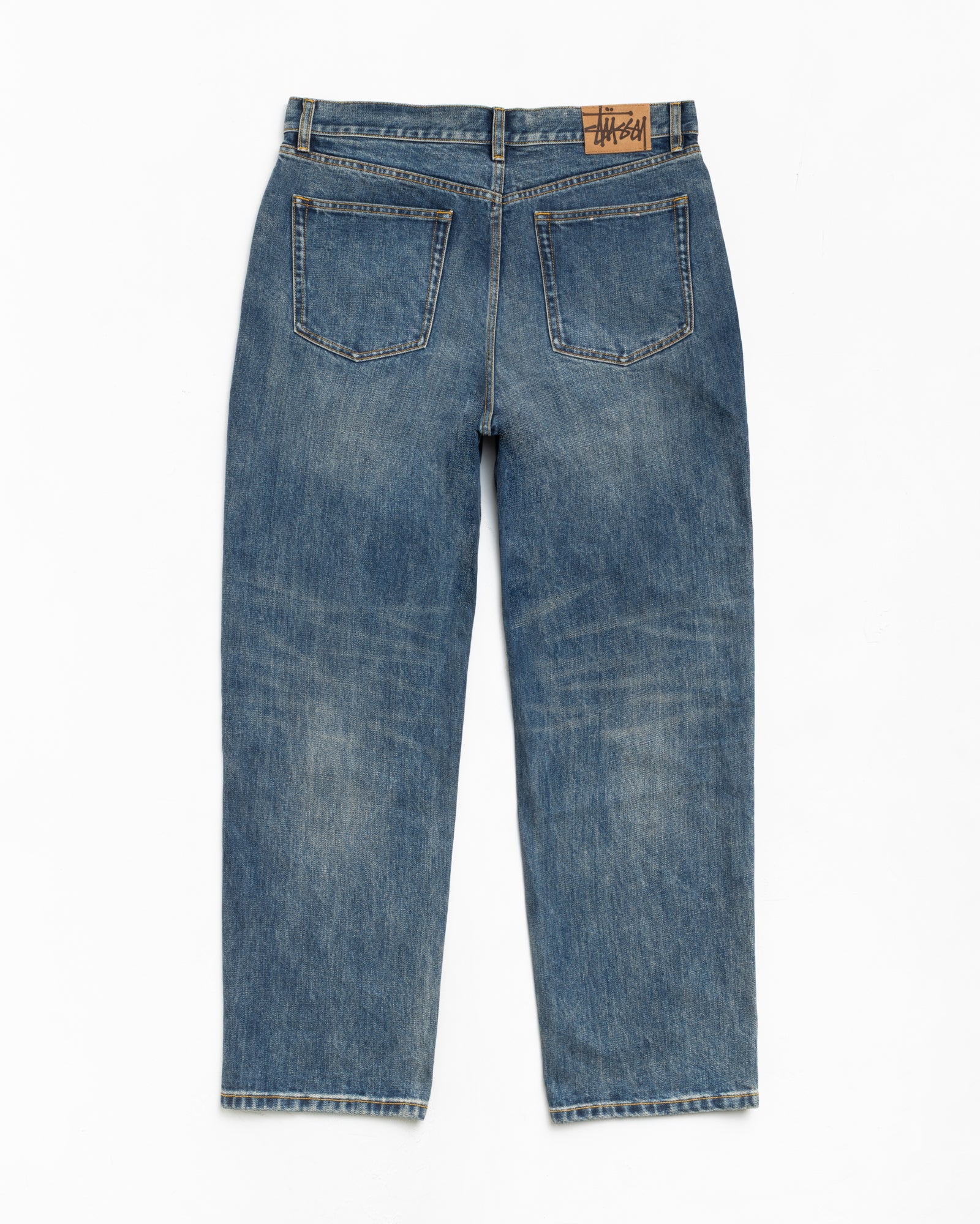 Blue slub denim jeans, back view with two patch pockets and tan branded waistband patch
