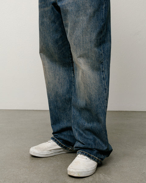 Blue slub denim jeans, relaxed baggy fit, shown on model legs with white trainers