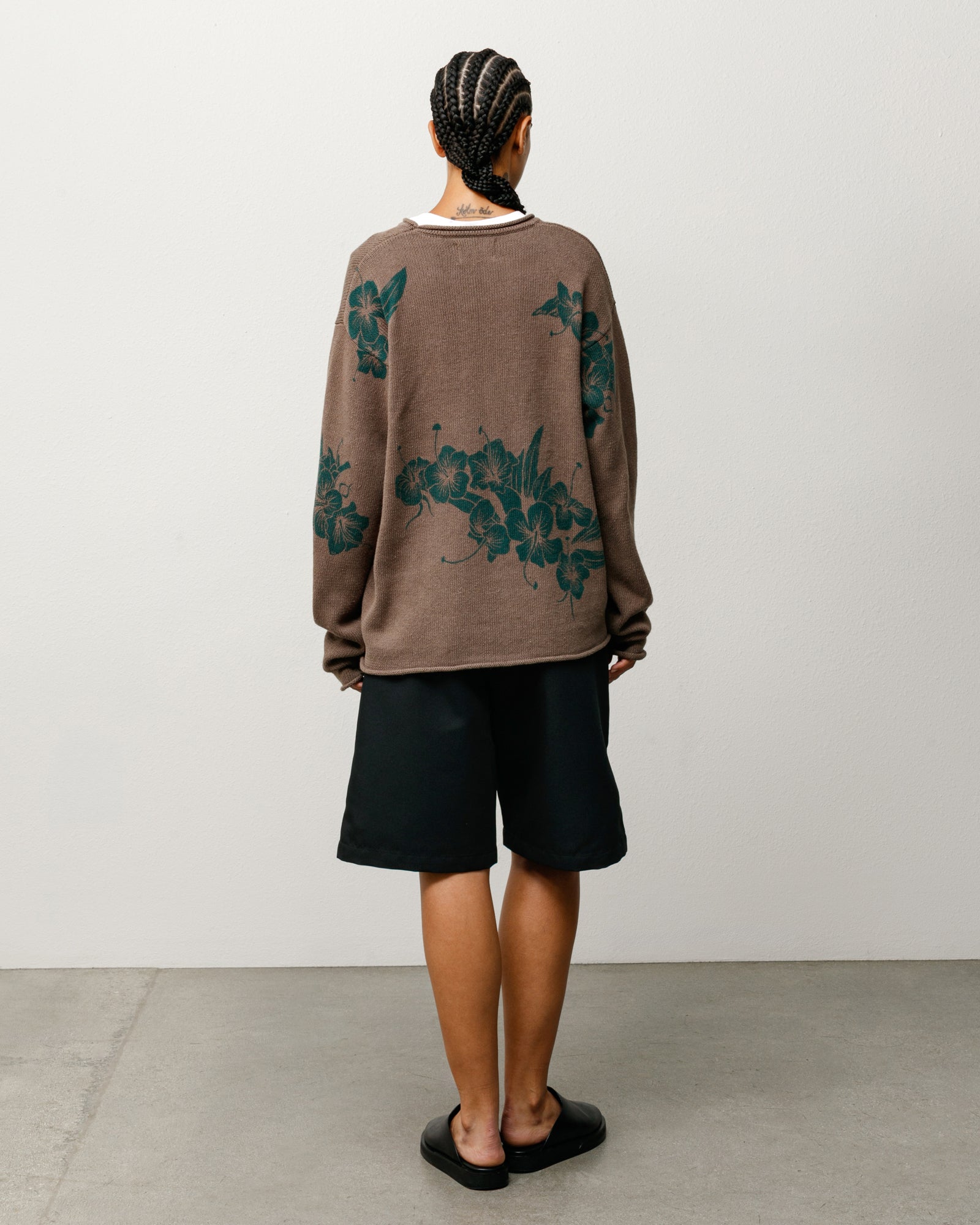 Brown knit jumper with green floral motif, back view on model