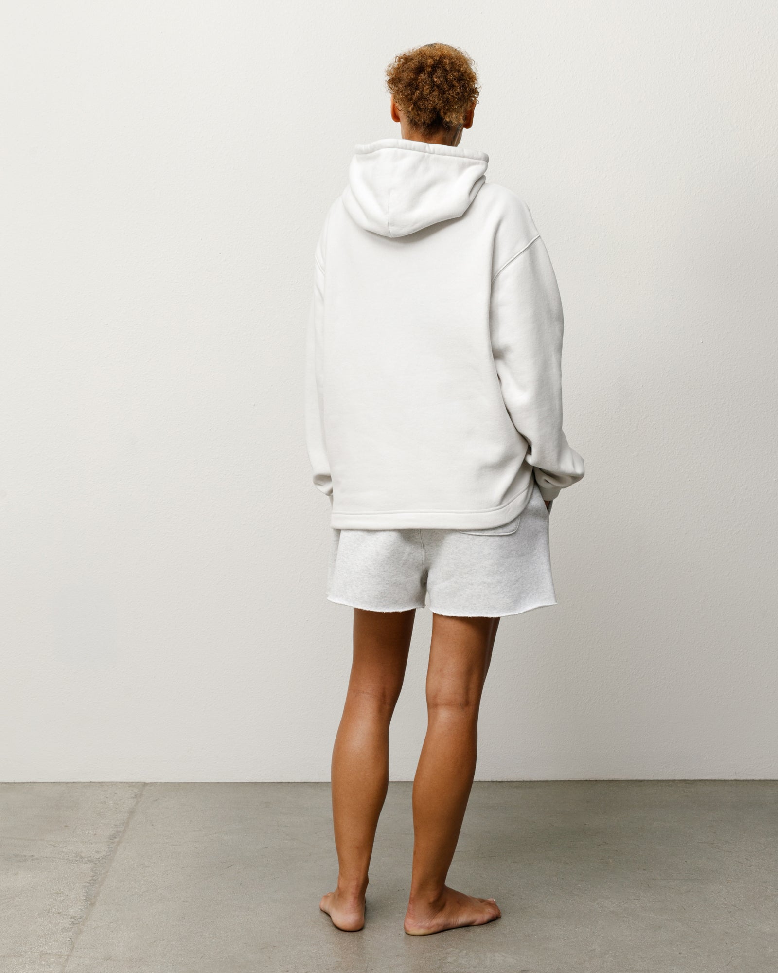 Stone pullover hoodie, unisex long sleeve, back view on-body in studio, relaxed fit