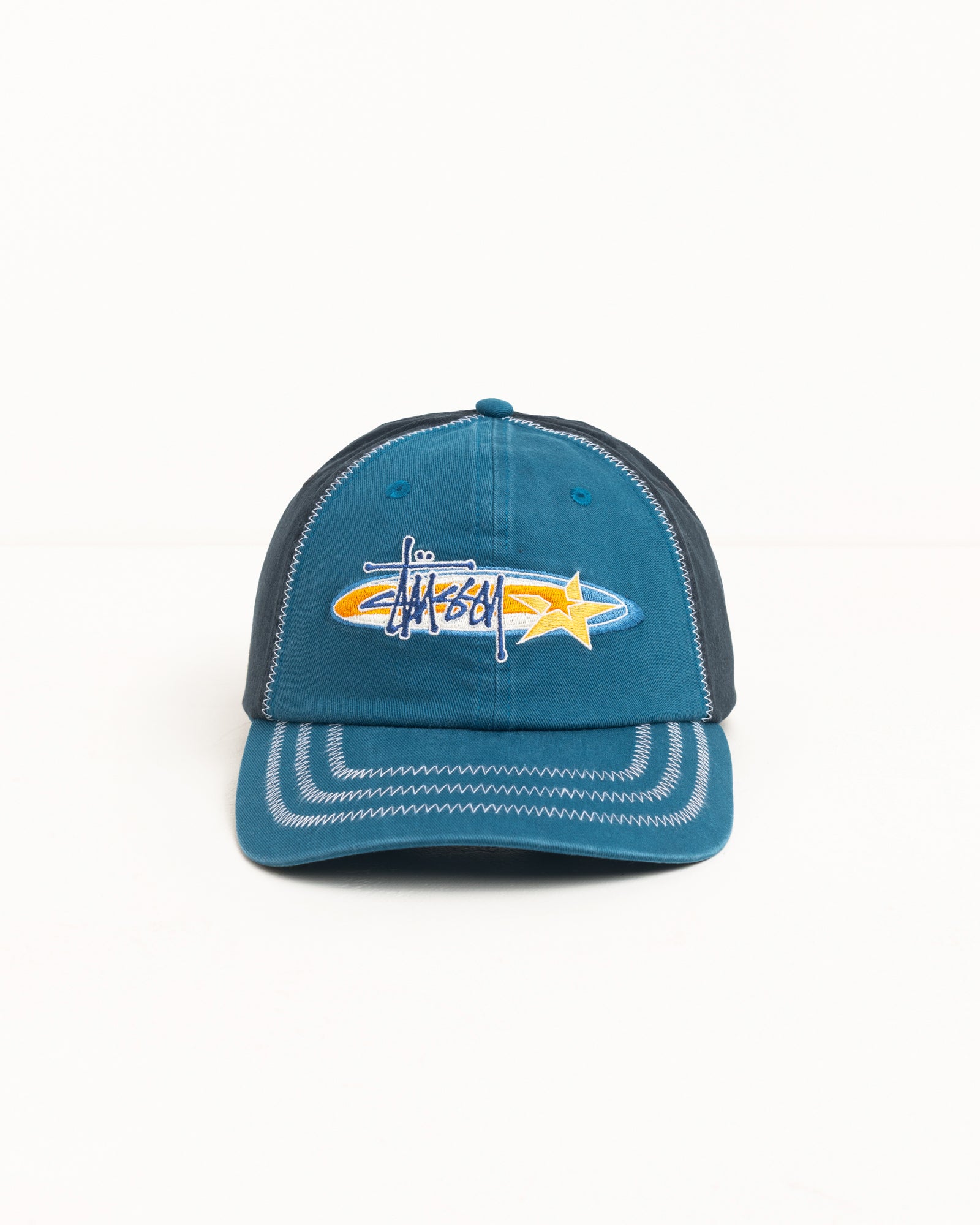 Blue cotton twill low-profile six-panel cap with logo and star embroidery, contrast zigzag stitching