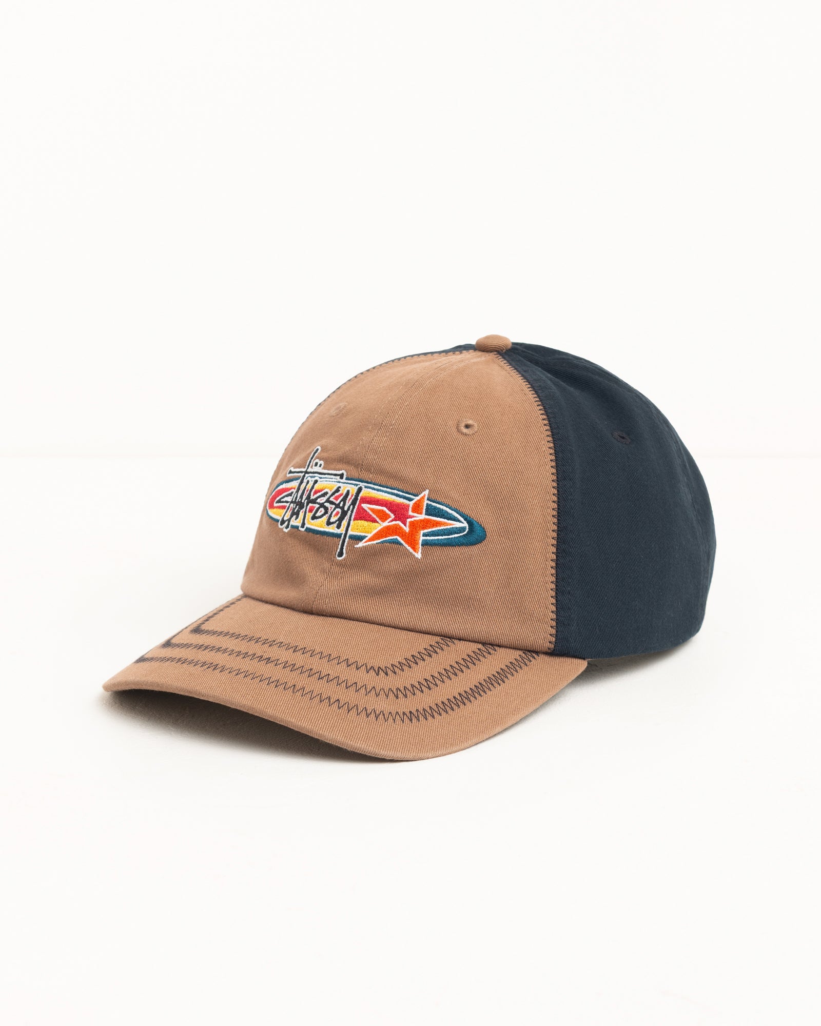 Two-tone brown and navy six-panel cap with embroidered star logo and zig-zag stitched brim