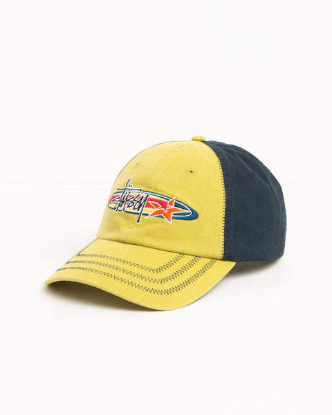 Lime cap with navy contrast panels, zig‑zag brim stitching and Stüssy logo embroidery