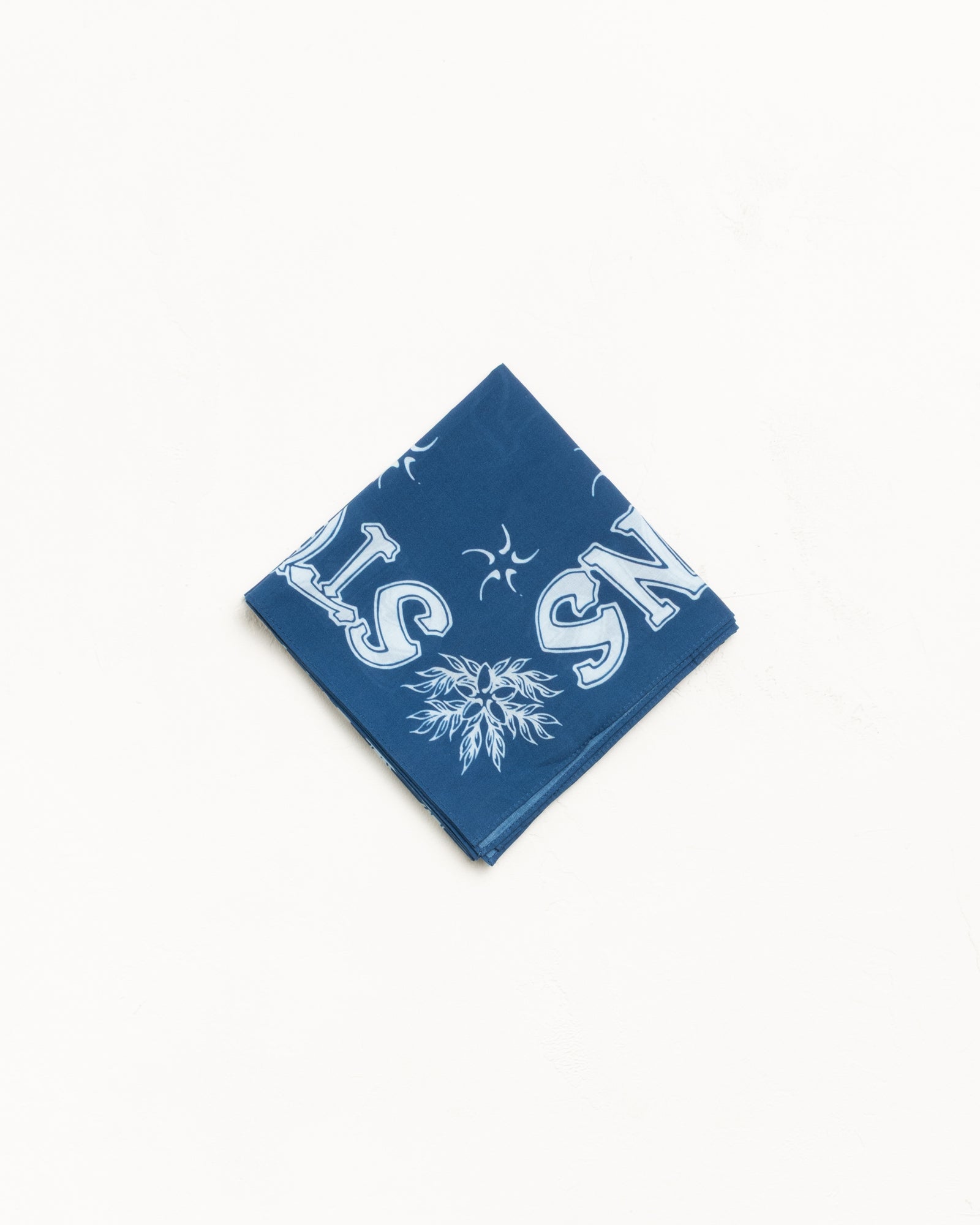 Blue bandana with white graphic print, folded neatly on a clean white background
