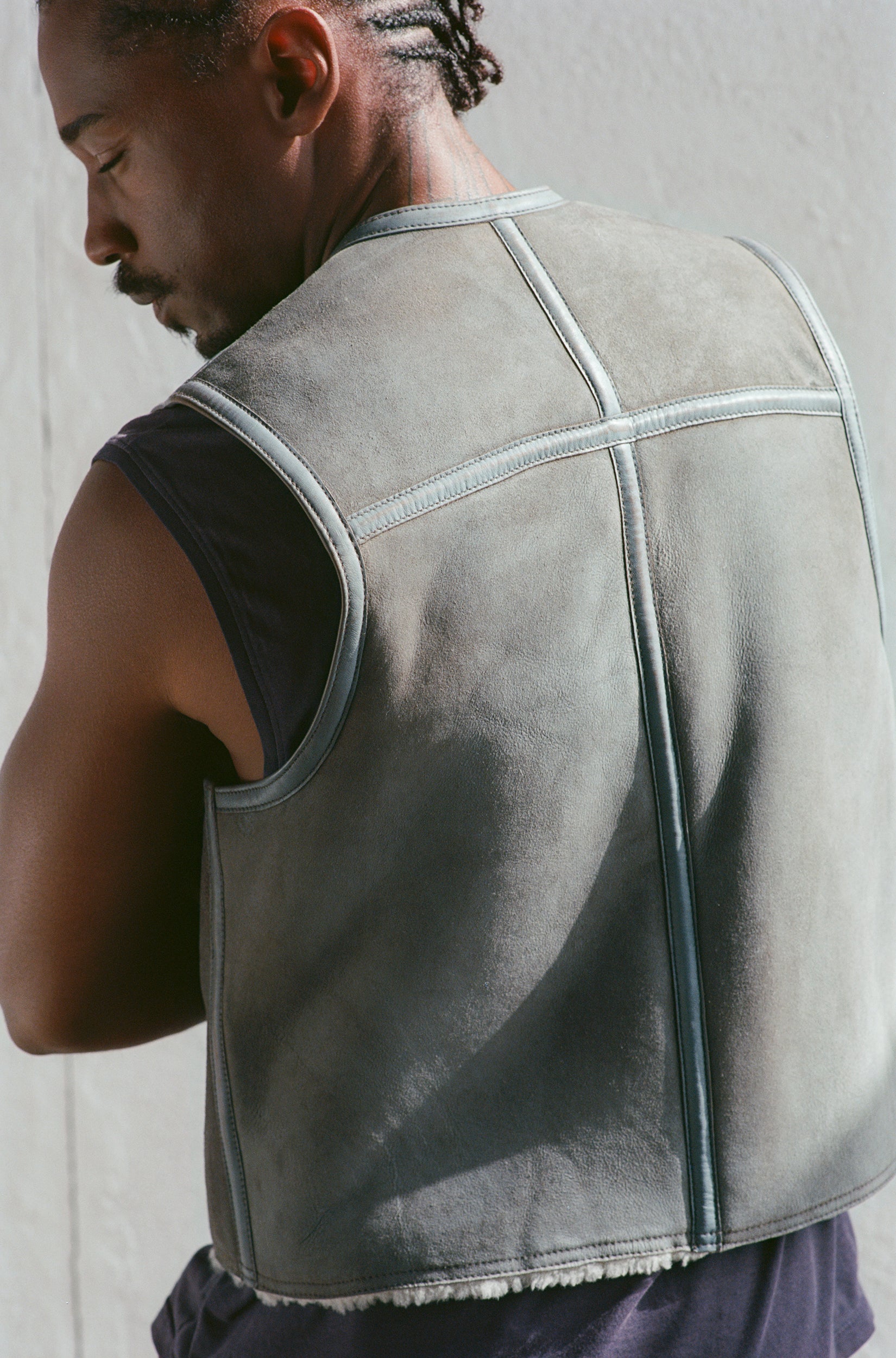 Model wearing the Our Legacy Reversible Shearling Vest in Overdyed from Stussy & Our Legacy Vol. 10. 